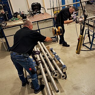 Zwei Männer in der Produktionshalle für Hydraulikrohre bei der Arbeit